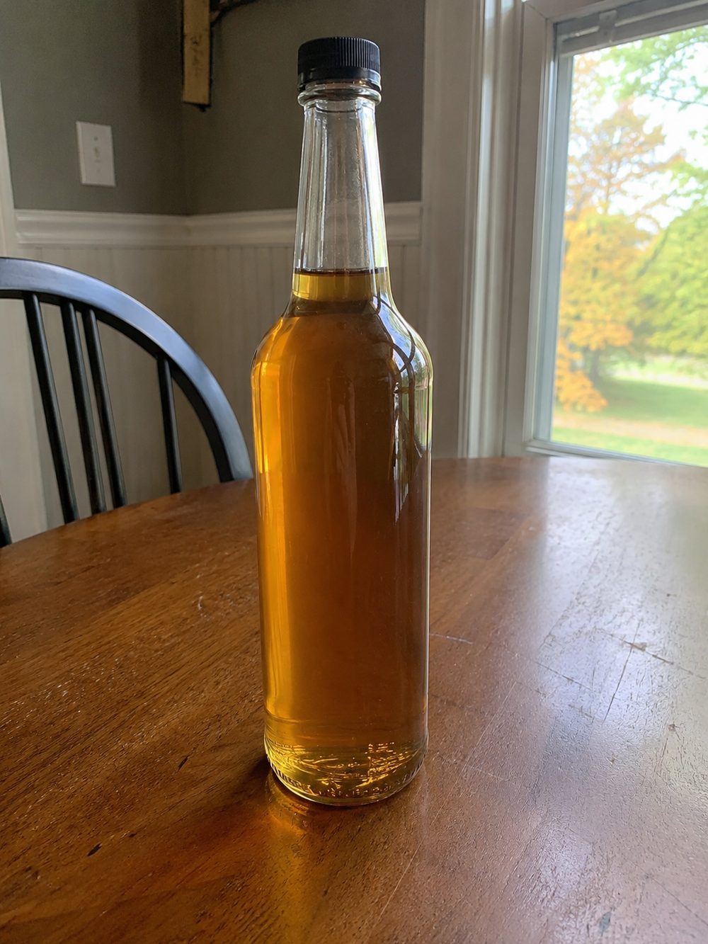 A bottle of homemade marshmallow coffee syrup in warm window light