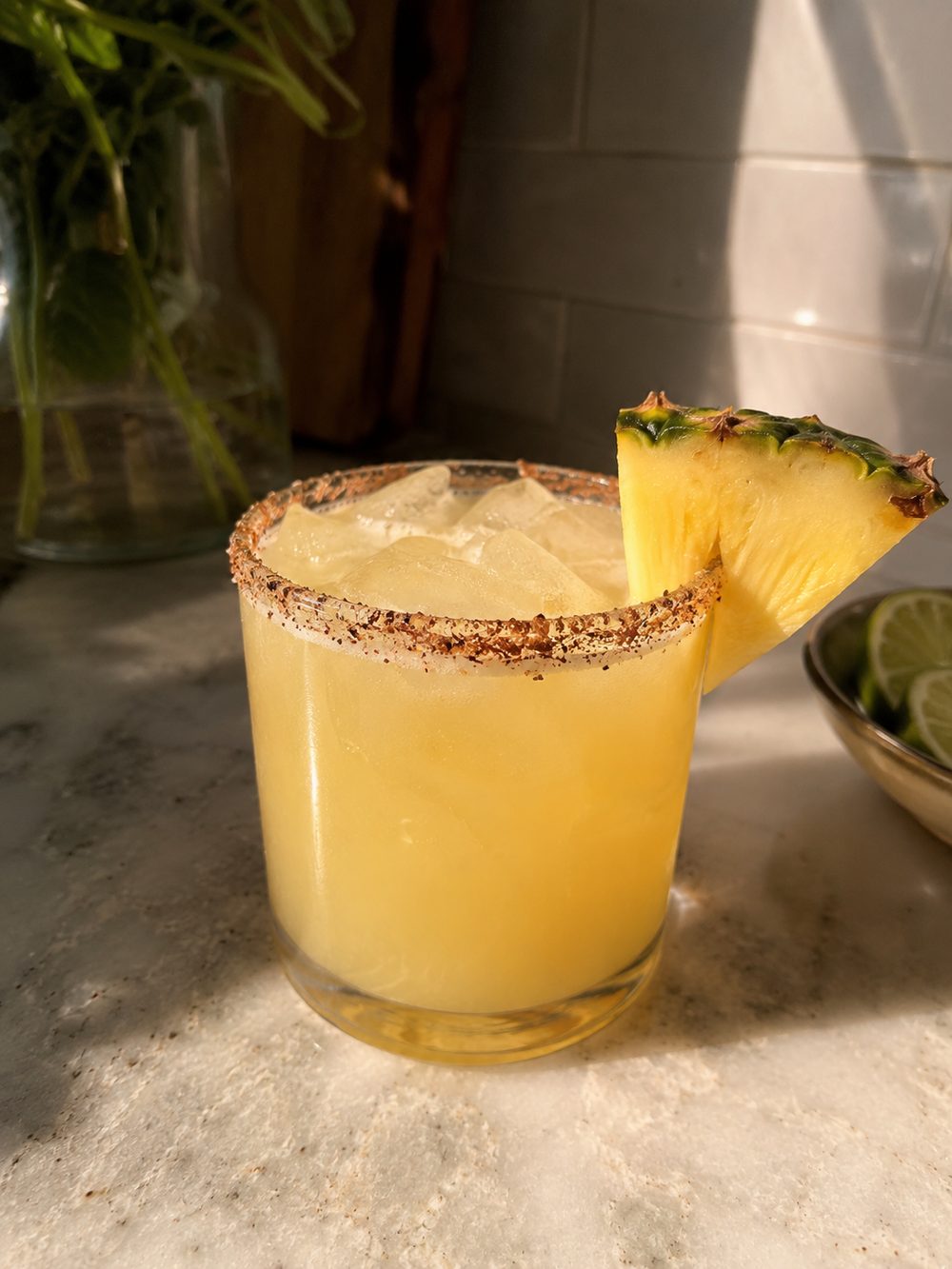 Pineapple mezcal margarita with a Tajin rim and a pineapple wedge